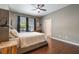 Comfortable main bedroom with a ceiling fan, wood floors, and a view to the outside at 3223 Blazing Star Ln, Harmony, FL 34773