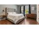 Serene main bedroom with a tufted headboard, dark wood floors, and natural light at 3223 Blazing Star Ln, Harmony, FL 34773