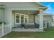 A covered patio featuring comfortable outdoor seating, a ceiling fan, and a view of the well-maintained backyard at 3223 Blazing Star Ln, Harmony, FL 34773