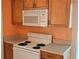 Kitchen with white oven/stove, white microwave, and wooden cabinets at 3516 Ridgemont Rd, Orlando, FL 32808
