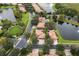 An aerial landscape reveals homes along tree-covered streets and a nearby community lake with a water feature at 390 Anessa Rose Loop, Ocoee, FL 34761