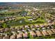 High above, a network of tree-lined streets encircle homes, a lake with a fountain, and community areas at 390 Anessa Rose Loop, Ocoee, FL 34761