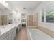 Spacious bathroom featuring double sinks, soaking tub, and a separate glass shower at 390 Anessa Rose Loop, Ocoee, FL 34761