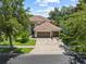 Beautiful two-story home with a three-car garage, a brick driveway, and mature landscaping in a sunny setting at 390 Anessa Rose Loop, Ocoee, FL 34761
