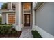 Elegant front entryway with a decorative glass door, sidelights, and manicured landscaping at 390 Anessa Rose Loop, Ocoee, FL 34761