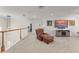 Cozy loft area features a leather chair, TV, and access to other parts of the home at 390 Anessa Rose Loop, Ocoee, FL 34761