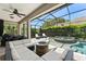 Outdoor living area with a ceiling fan, dining table, lounge chairs, a fire pit, and a pool at 390 Anessa Rose Loop, Ocoee, FL 34761