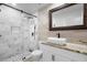 Modern bathroom with glass shower, marble tile, updated sink and granite countertops at 4102 Boca Woods Dr, Orlando, FL 32826