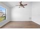 Bright bedroom with hardwood floors, ceiling fan, and a large window at 4102 Boca Woods Dr, Orlando, FL 32826