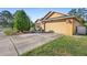 Exterior view of the side of the home, featuring a two-car garage and freshly cut lawn at 4102 Boca Woods Dr, Orlando, FL 32826