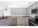 Modern kitchen featuring gray cabinets, granite countertops, and stainless steel appliances at 4102 Boca Woods Dr, Orlando, FL 32826