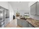 Modern kitchen featuring gray cabinets, granite countertops, and stainless steel appliances at 4102 Boca Woods Dr, Orlando, FL 32826