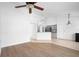 Open-concept living room with wood and tile flooring, leading into a modern kitchen at 4102 Boca Woods Dr, Orlando, FL 32826