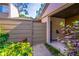 Close-up of the townhome's entry area with a privacy fence, tropical plants, and a covered entryway at 458 Meadowood Blvd, Fern Park, FL 32730