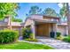 Charming townhome showcasing a covered carport, complemented by mature landscaping and verdant green spaces at 458 Meadowood Blvd, Fern Park, FL 32730