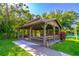 An outdoor gazebo with benches and picnic tables surrounded by lush greenery provides a perfect gathering spot at 458 Meadowood Blvd, Fern Park, FL 32730