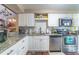 Modern kitchen with white cabinets, granite countertops, and stainless steel appliances offers a sleek design at 458 Meadowood Blvd, Fern Park, FL 32730