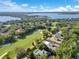 Picturesque aerial view with golf course, a lake, and homes with swimming pools nestled among trees at 5157 Latrobe Dr, Windermere, FL 34786
