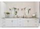Spacious bathroom featuring double vanity with granite countertops, white cabinets, and oval framed mirrors at 5157 Latrobe Dr, Windermere, FL 34786