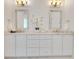 Elegant bathroom with a double vanity, marble countertops, and matching framed mirrors at 5157 Latrobe Dr, Windermere, FL 34786