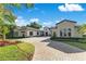 A gorgeous exterior view of this home shows its beautifully maintained lawn and paver driveway at 5157 Latrobe Dr, Windermere, FL 34786
