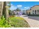 Exterior of home with landscaped circle drive, seen through tree with purple flowers at 5157 Latrobe Dr, Windermere, FL 34786