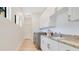 Modern laundry room with granite counters, white cabinets, and stainless steel appliances at 5157 Latrobe Dr, Windermere, FL 34786