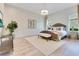 Neutral bedroom with upholstered headboard, light wood floors, and modern chandelier at 5157 Latrobe Dr, Windermere, FL 34786