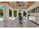 Covered outdoor kitchen and dining area featuring stainless appliances, wood ceiling, and views of the pool and landscaped backyard at 5157 Latrobe Dr, Windermere, FL 34786