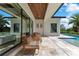 Relaxing outdoor patio with wicker seating overlooking the sparkling pool and lush greenery at 5157 Latrobe Dr, Windermere, FL 34786