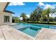 Beautiful pool and spa with blue tile accents surrounded by travertine and tropical landscaping at 5157 Latrobe Dr, Windermere, FL 34786