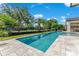 Resort-style pool with tropical landscaping, manicured lawn, and outdoor kitchen area overlooking the golf course at 5157 Latrobe Dr, Windermere, FL 34786
