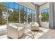 Bright sunroom with a view of pool, featuring hardwood floors and cozy chairs at 5157 Latrobe Dr, Windermere, FL 34786