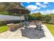 Brick paved patio with fire pit and seating surrounded by lush landscaping and grass at 5335 Bay Side Dr, Orlando, FL 32819