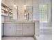 Elegant bathroom featuring double sinks with granite countertops and a modern glass block window at 5335 Bay Side Dr, Orlando, FL 32819