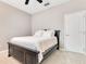 Simple bedroom featuring a dark wooden bedframe, neutral carpet and walls, and a ceiling fan at 5335 Bay Side Dr, Orlando, FL 32819