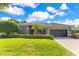 Charming single-story home features a well-manicured lawn, trimmed hedges, and a two-car garage at 5335 Bay Side Dr, Orlando, FL 32819