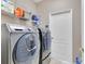 Modern laundry room featuring a front-load washer and dryer, and storage shelves at 5335 Bay Side Dr, Orlando, FL 32819