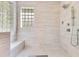 Modern walk-in shower featuring stylish tiling, glass block window, and high-end fixtures at 5335 Bay Side Dr, Orlando, FL 32819