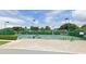 Exterior view of tennis courts surrounded by green shrubs and trees in a beautiful park setting at 5335 Bay Side Dr, Orlando, FL 32819