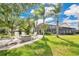 Inviting backyard patio with Adirondack chairs, a fire pit, and a screened-in porch, perfect for outdoor living at 5944 Lake Melrose Dr, Orlando, FL 32829