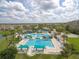 An aerial view showcases a community pool with several pools, palm trees, and seating areas at 5944 Lake Melrose Dr, Orlando, FL 32829