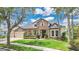Charming home featuring stone accents, lush landscaping, and a well-manicured lawn at 5944 Lake Melrose Dr, Orlando, FL 32829