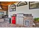 Built-in outdoor grill station with stone accents and convenient mini-fridge on the patio at 5944 Lake Melrose Dr, Orlando, FL 32829