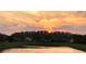 Scenic view of a sunset over a tranquil pond and surrounding community at 5944 Lake Melrose Dr, Orlando, FL 32829