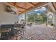 A covered pool patio featuring a bar, chairs, and an outdoor TV at 5944 Lake Melrose Dr, Orlando, FL 32829