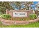 Community entrance sign featuring a brick facade, landscaping, and the 'Melrose' name at 5944 Lake Melrose Dr, Orlando, FL 32829