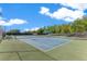 Outdoor tennis court featuring blue surface, shaded seating area, and surrounding greenery offering a recreational amenity at 5944 Lake Melrose Dr, Orlando, FL 32829