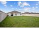 Home's backyard featuring lush green grass and a sliding door at 601 Watusi Way, St Cloud, FL 34772
