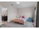 Cozy bedroom with neutral tones, soft carpet, and an adjacent bathroom at 601 Watusi Way, St Cloud, FL 34772